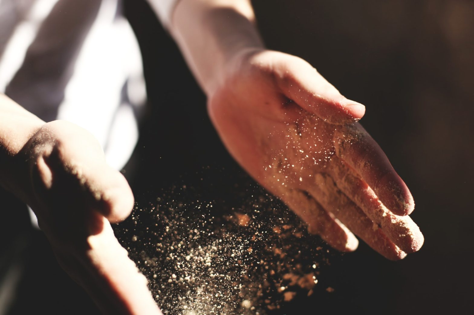 Dust flowing around person's hands
